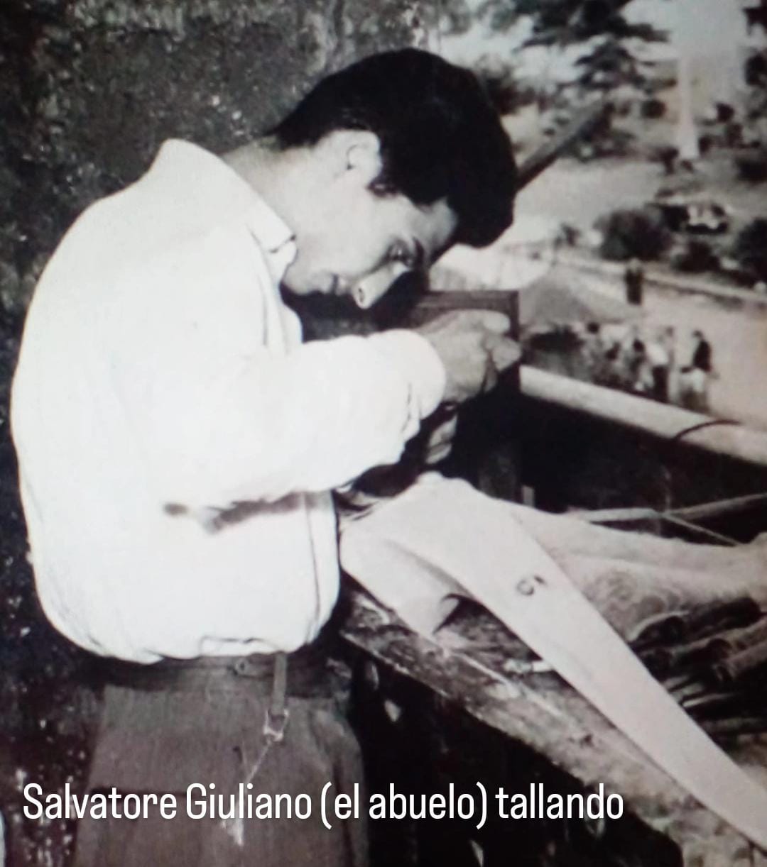 Panorámica de un abuelo llamado Salvatore Giuliano tallando madera en un taller artesanal en Argentina.